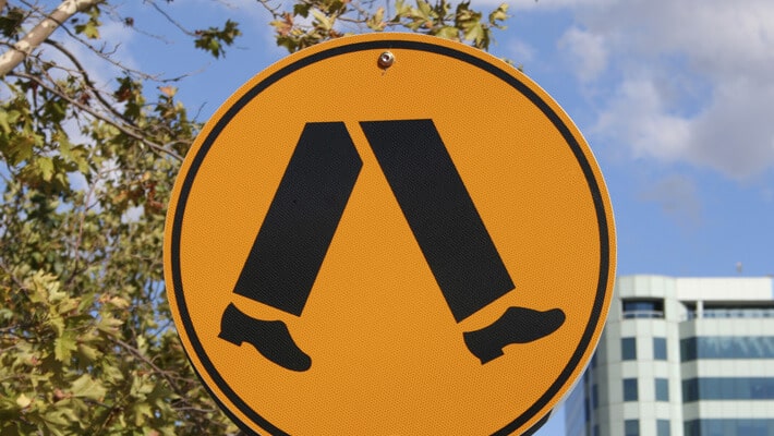 Señalización de tránsito de color amarillo de unos pies como regla básica de seguridad vial para peatones