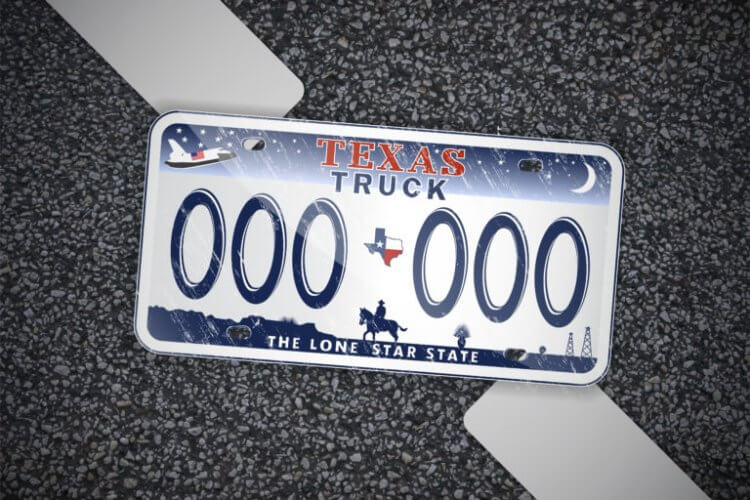Placa de auto con el nombre en inglés de Texas Truck sobre un fonde de asfalto