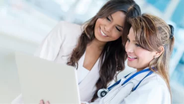 Mujer médico y chica revisando el obamacare 2021 seguro en una laptop blanca