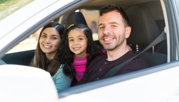 familia hispana feliz en su auto con seguro en estados unidos