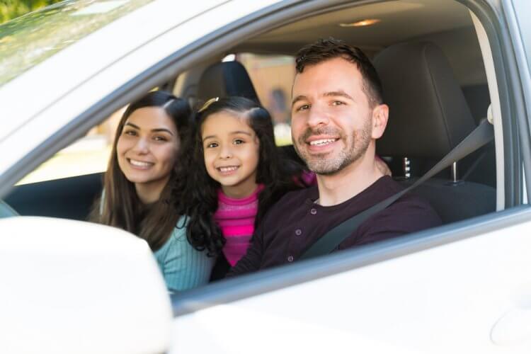 familia hispana feliz en su auto con seguro en estados unidos