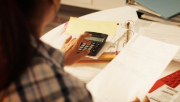 mujer usando calculadora en escritorio para calcular deducible