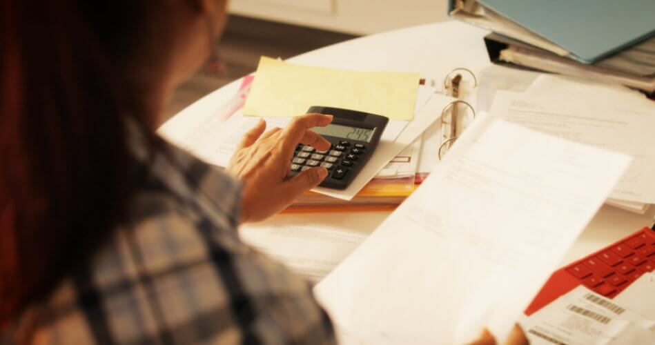 mujer usando calculadora en escritorio para calcular deducible