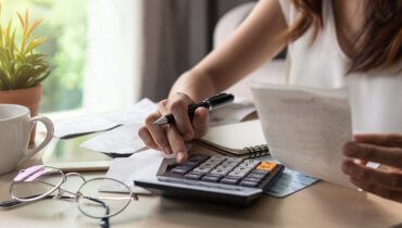mujer con calculadora haciendo calculando precio de seguro de auto