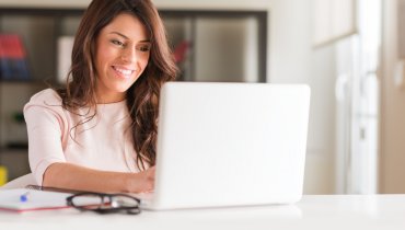 mujer hispana en laptop sonriendo