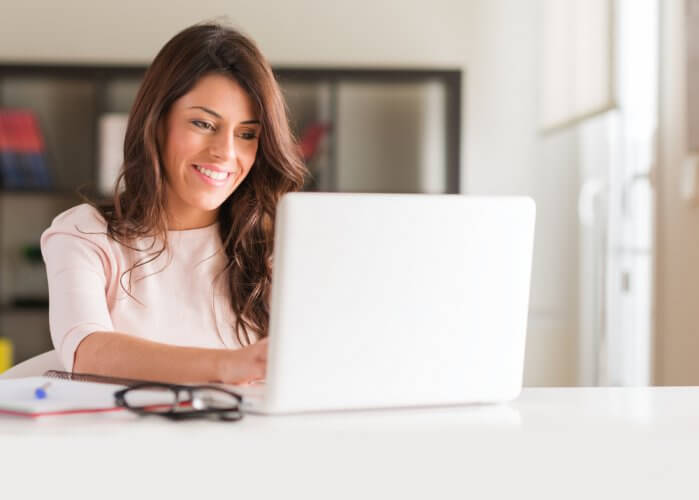 mujer hispana en laptop sonriendo