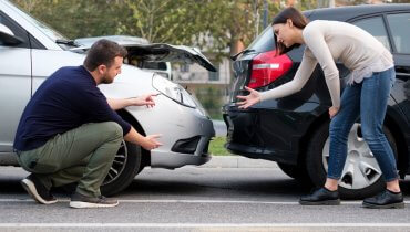 dos personas en un accidente automovilistico discutiendo quien tiene la culpa