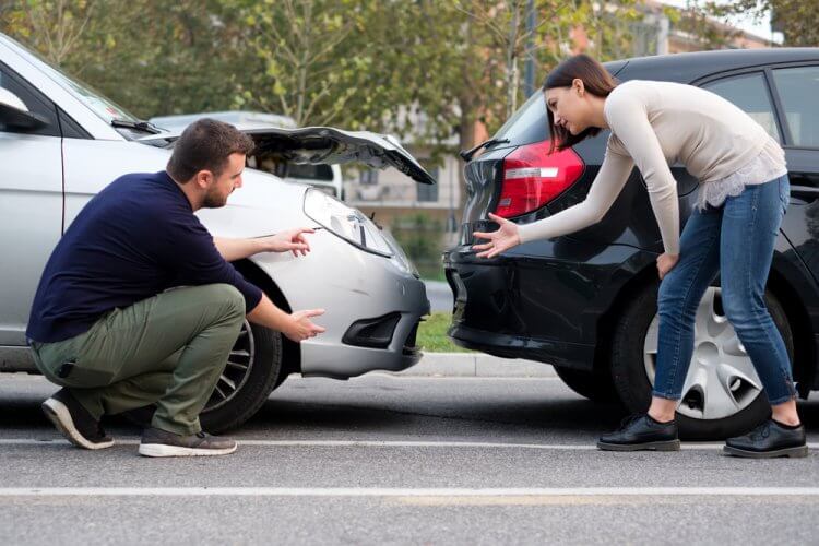 dos personas en un accidente automovilistico discutiendo quien tiene la culpa