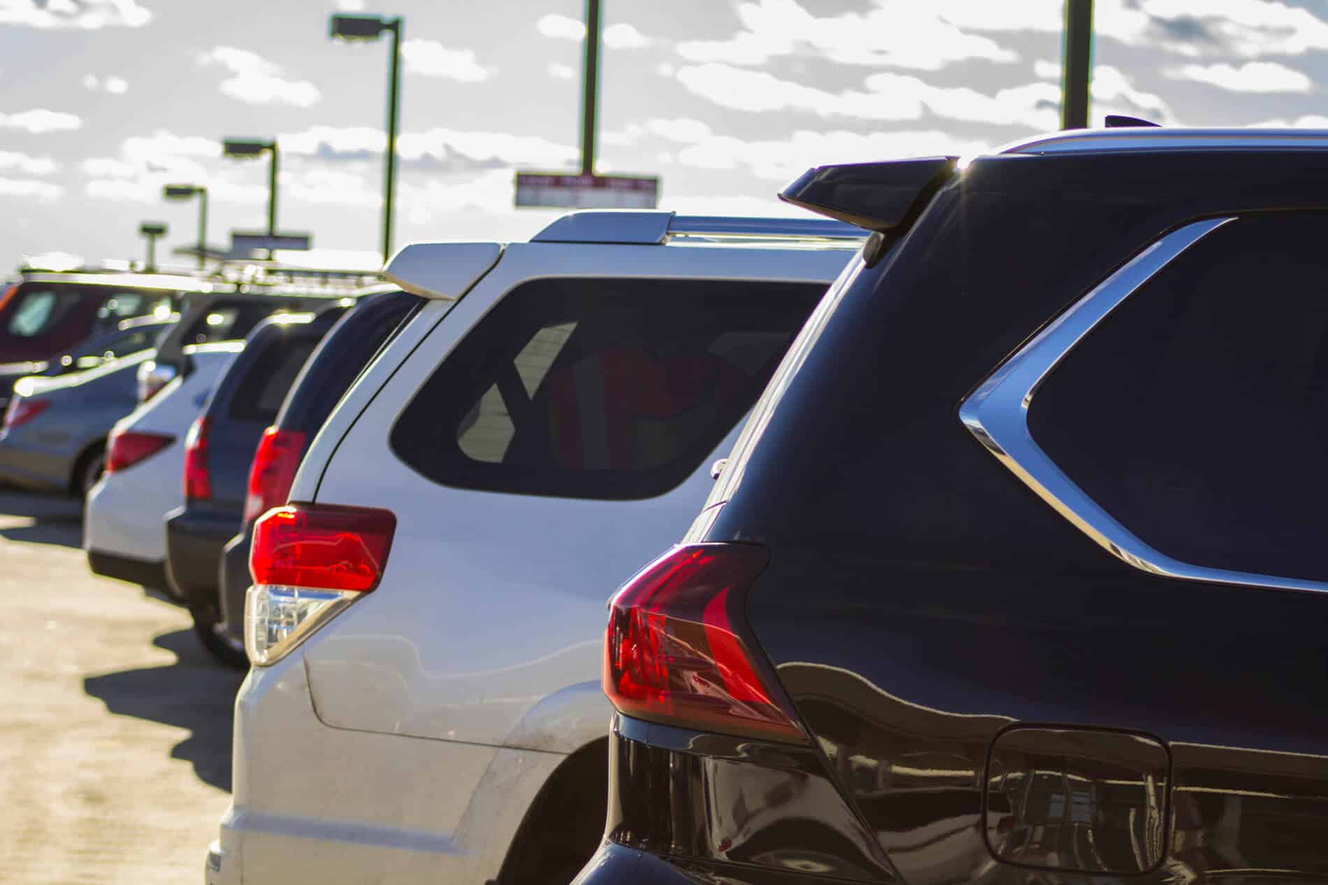 Estacionamiento que muestra solo la parte trasera de varias camionets y autos