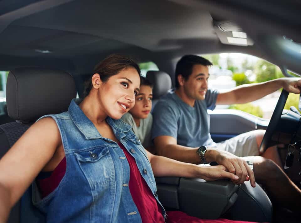 Pareja jovencon hijo dentro de un auto