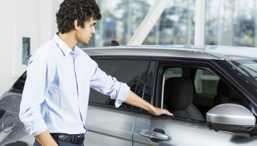 Hombre joven observando un auto que quiere comprar