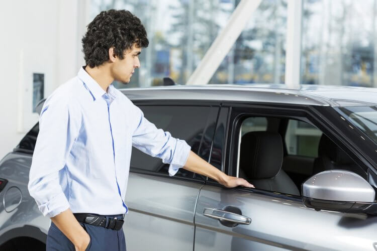 Hombre joven observando un auto que quiere comprar