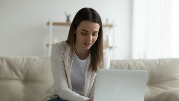 Mujer-joven-tecleando-en-su-computadora-portatil