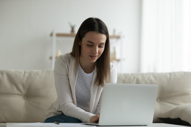 Mujer-joven-tecleando-en-su-computadora-portatil