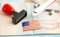 Pasaporte con sello, bandera de Estados Unidos y avión de fondo, representando los requisitos para viajar en Estados Unidos.