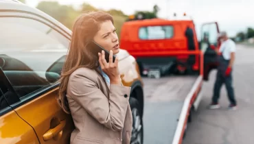 Mujer solicitando asistencia en carretera para su auto.