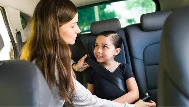 Mujer joven dejando sola a niña en el auto.