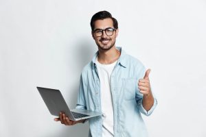 Profesional sosteniendo una laptop y sonriendo tras encontrar oportunidades laborales con apps para buscar trabajo en EEUU.