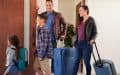 Familia con equipaje saliendo de su casa para irse de vacaciones