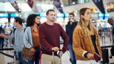 Viajeros en aeropuerto esperando turno, reflejando requisitos al viajar con residencia americana en vuelos internacionales.
