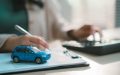 Documentación relacionada con un seguro de auto junto a un vehículo en miniatura, destacando la importancia de completar la solicitud con datos precisos para evitar problemas con la cobertura o el pago de un reclamo.