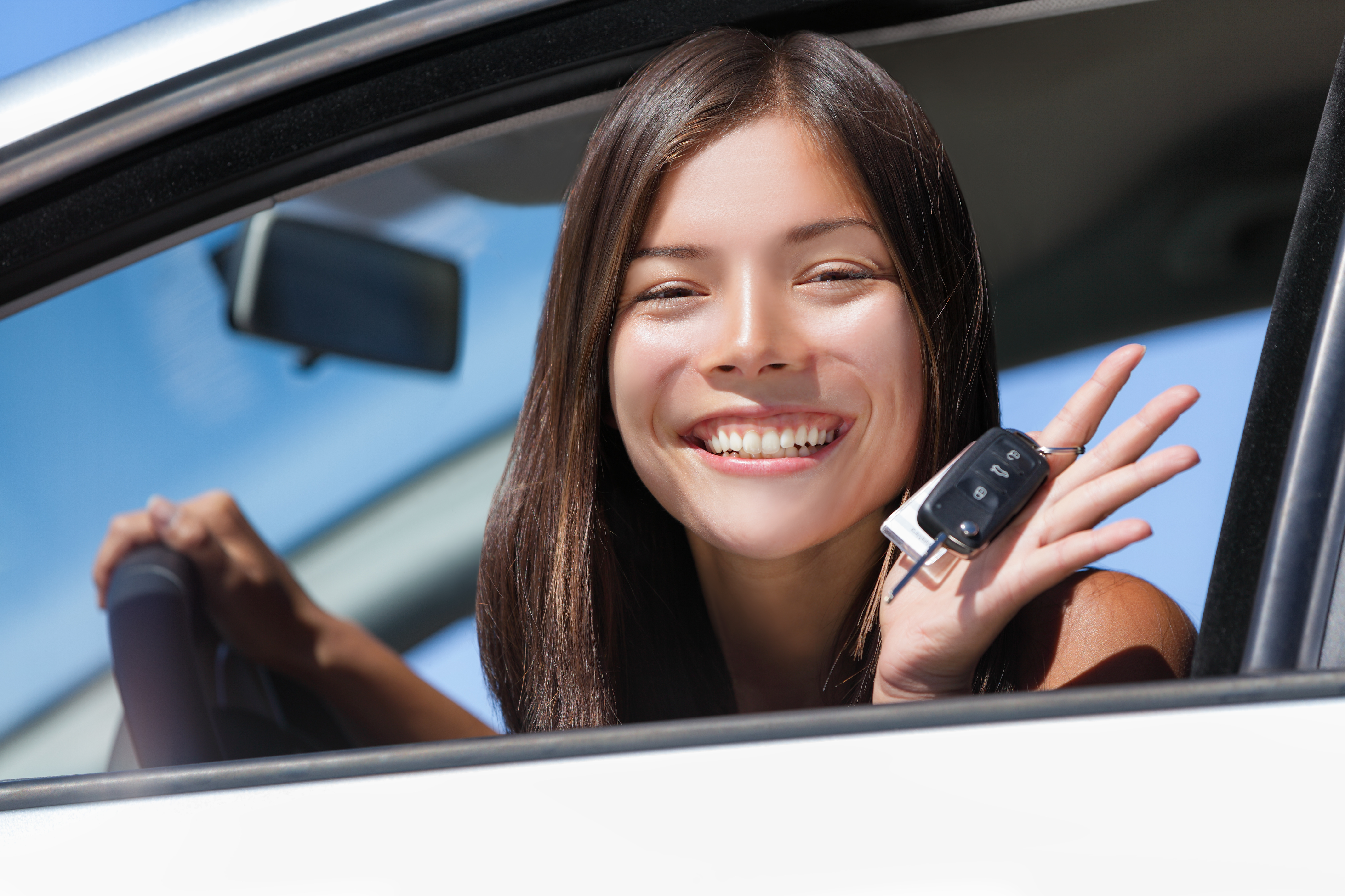 mujer_adolescente_sonriendo_frente_a_volante_auto_blanco