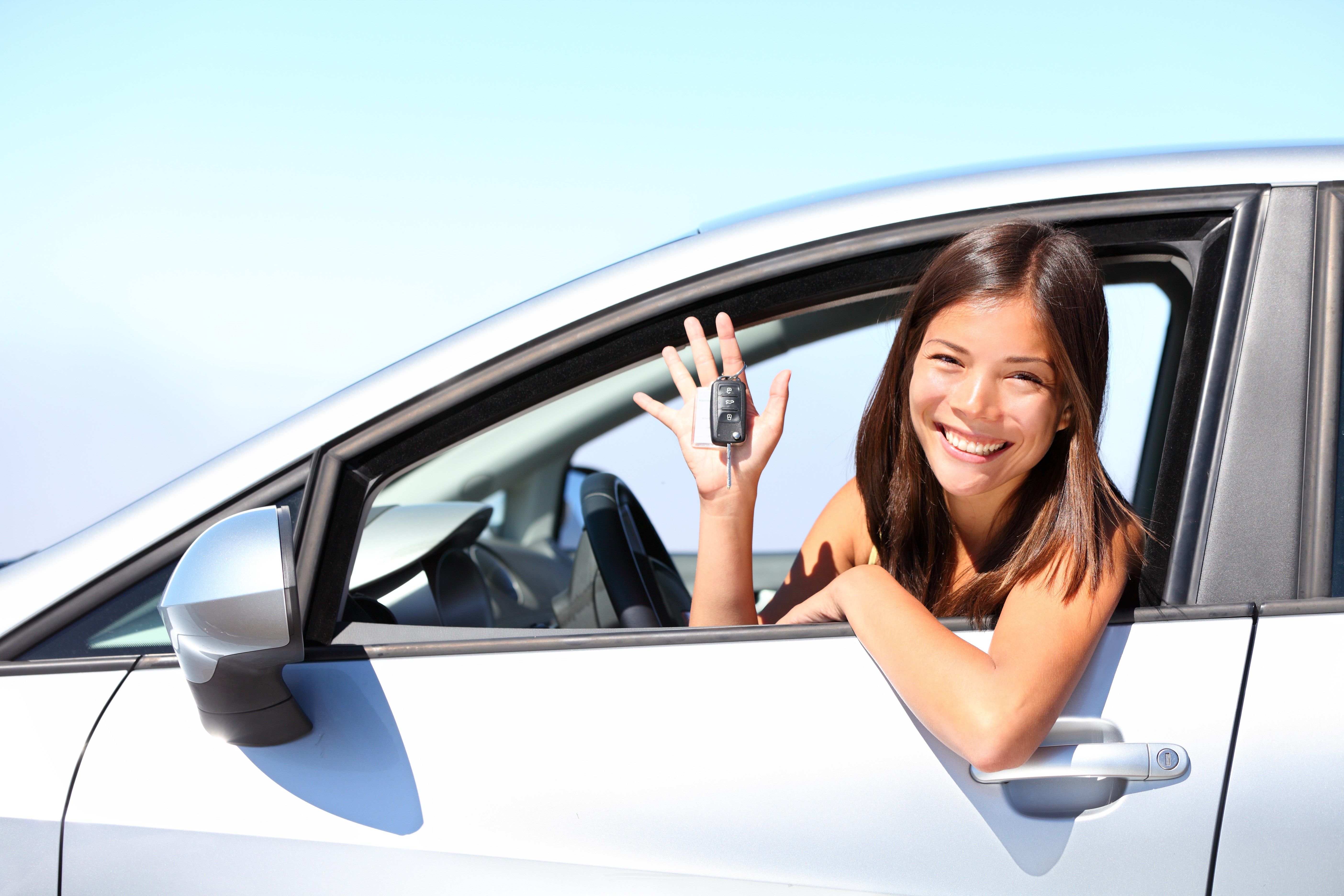 mujer_feliz_en_auto_blanco_con_llaves_en_mano