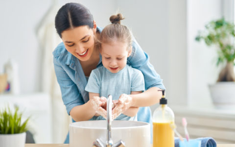 mama lavandole las manos a su hija para prevenir covid-19