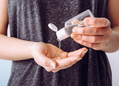 mujer usando gel antibacterial contra el coronavirus