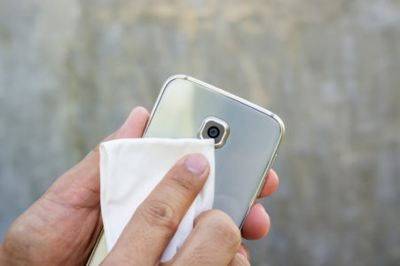 hombre limpiando su telefono movil para prevenir covid-19