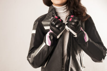 mujer usando chaqueta y guantes de seguridad para manejar moto