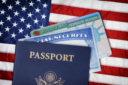 pasaporte, tarjeta de seguridad social y tarjeta de migracion sobre una bandera de estados unidos las consecuencias de un DUI