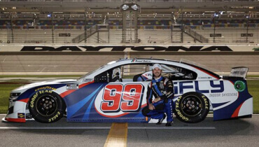 El campeón de las series NASCAR Cup y Xfinity Daniel Suárez frente a su carro de carreras