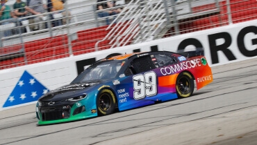 Foto de accion del carro de daniel suarez en la pista con el numero 99 en la puerta al frente