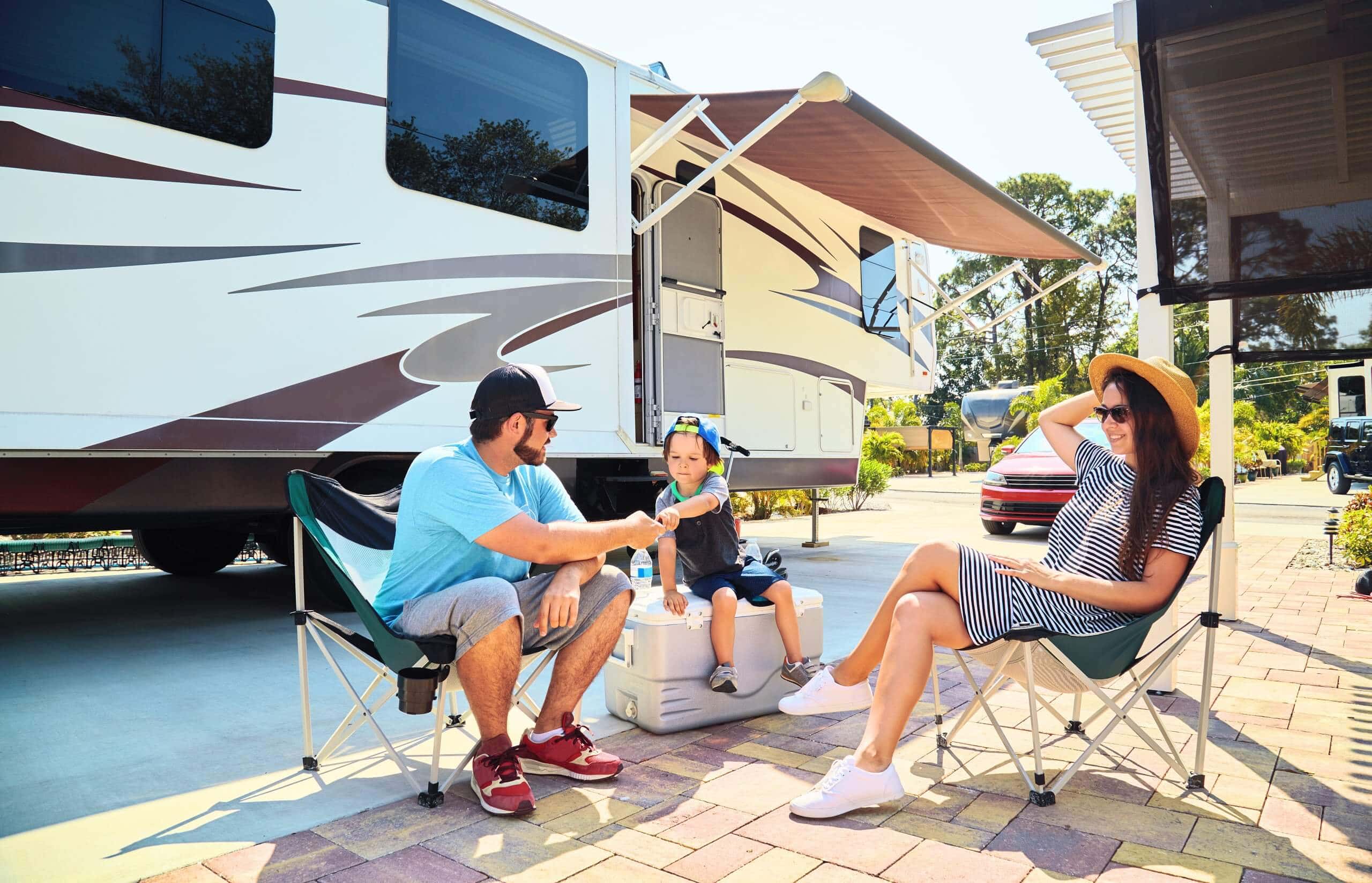 Familia hispana conviviendo en el exterior de su RV mientras goza de un seguro de casa rodante/RV