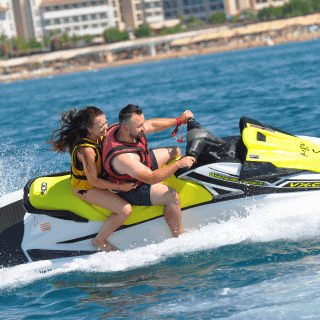 Pareja vacacionando en la playa mientras disfruta de su seguro de motos acuáticas