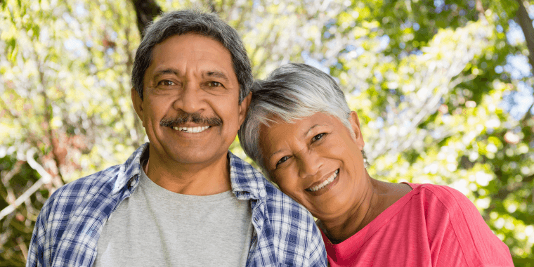 Pareja hispana mayor sonriendo mientras disfruta de un seguro de vida