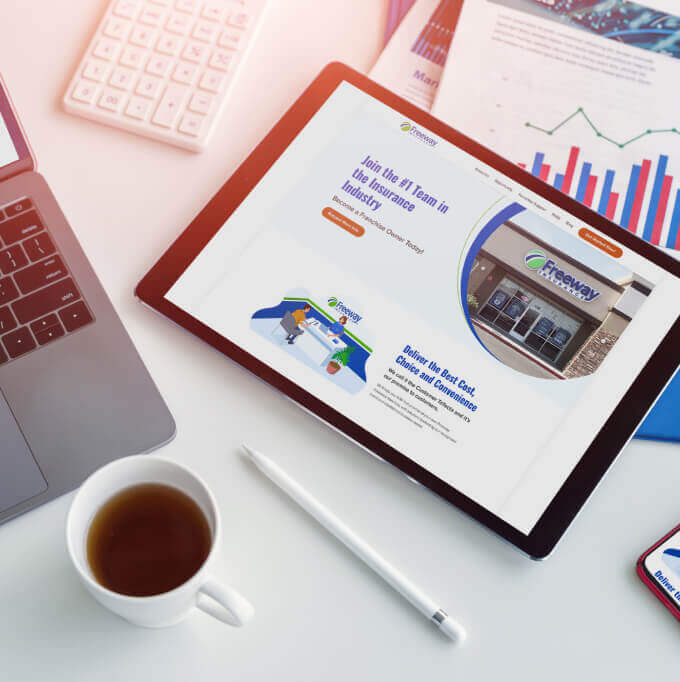 Tableta en escritorio mostrando página web de freeway seguros franquicia