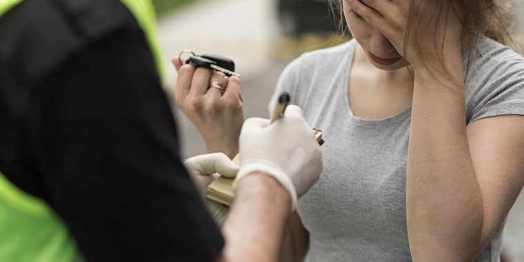 Mujer siendo detenida por un policia de tránsito por un DUI