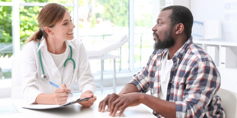 Doctora atiendea un paciente que pregunta por el periodo especial de inscripción de seguro medico