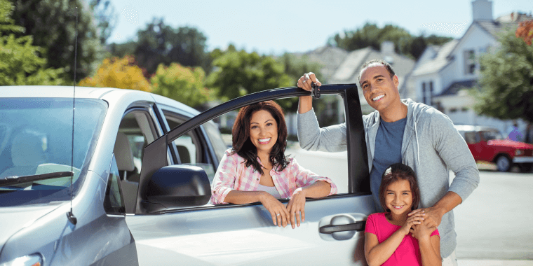 Familia afuera de su auto con la puerta abierta