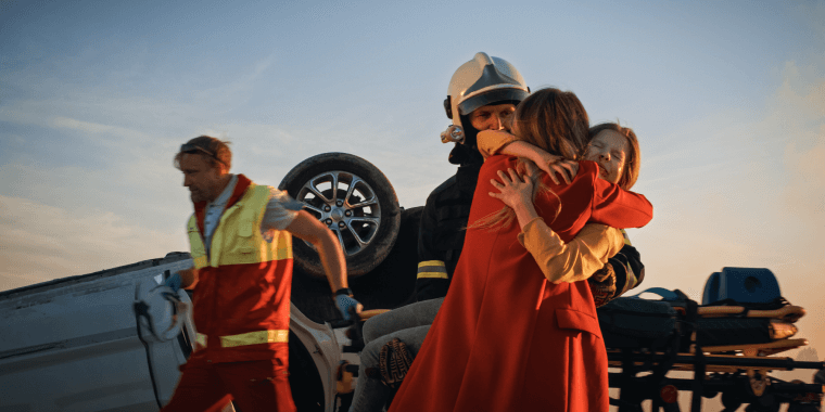 Madre abrazando a su pequeña hija después de un accidente de auto.