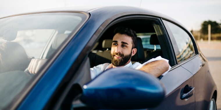 Hombre feliz conduciendo auto con la ventana abajo