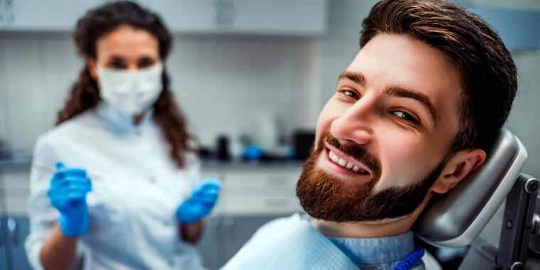 Hombre feliz en la silla dental.