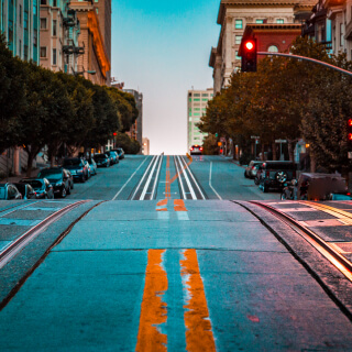 Calle vacía empinada de noche con un semáforo en rojo en San Francisco