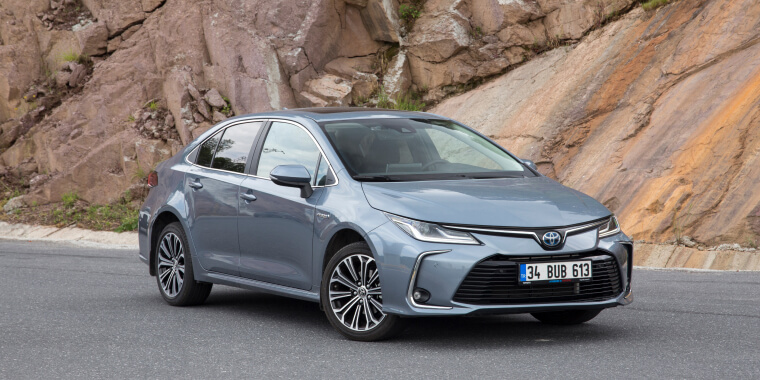 Toyota Corolla sobre una vía y de fondo una roca