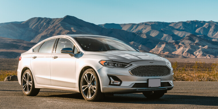 Ford Fusion color plata con unas montañas de fondo