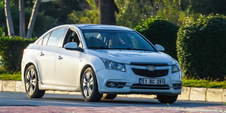 Chevrolet Cruze blanco parqueado en una tarde soleada de verano