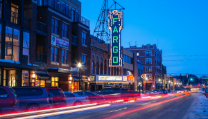 Edificios, teatro y tráfico en la ciudad de Fargo en Dakota del Norte al anochecer.