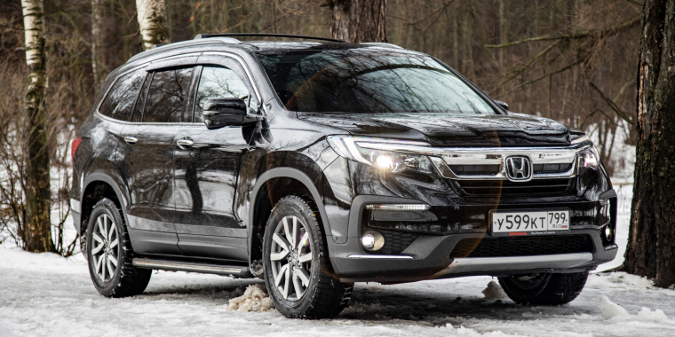 Honda Pilot fuera de la carretera en un bosque sobre la nieve